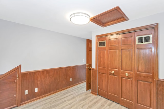 6N772 Tuscola Ave, Saint Charles, IL 60174 - unfurnished bedroom featuring wainscoting, light wood-style floors, a closet, and wooden walls