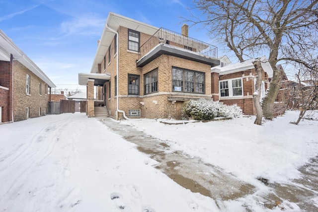 snow covered property featuring a balcony