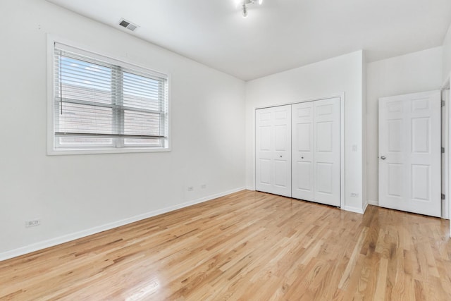 unfurnished bedroom featuring light wood-type flooring and a closet