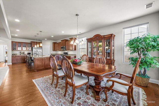 dining area with a notable chandelier, dark hardwood / wood-style floors, and sink