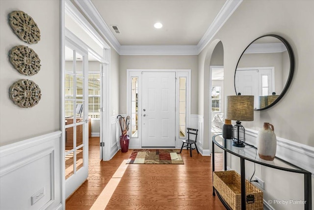 foyer entrance with hardwood / wood-style flooring and crown molding