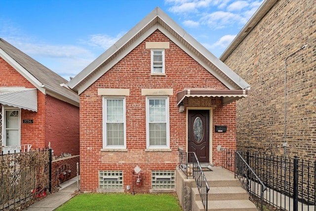 view of front of property featuring fence and brick siding