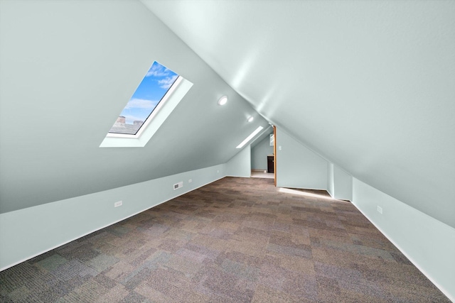 bonus room featuring carpet floors and vaulted ceiling with skylight