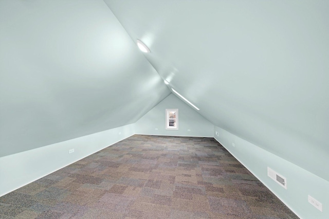 additional living space featuring carpet floors, lofted ceiling, and visible vents