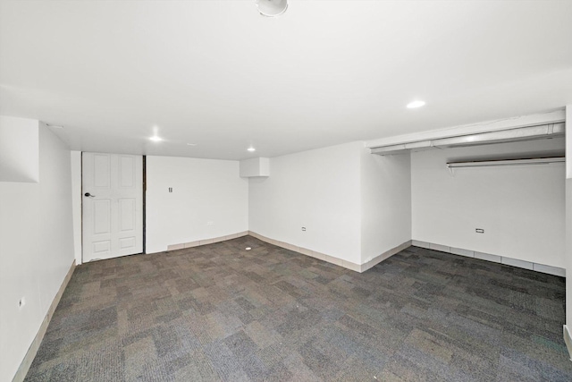 finished below grade area featuring baseboards, dark colored carpet, and recessed lighting