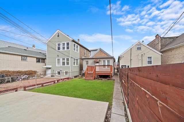 rear view of property with a fenced backyard, a yard, and a wooden deck