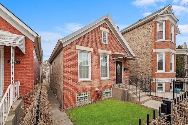 view of front of property featuring fence, a front lawn, and brick siding