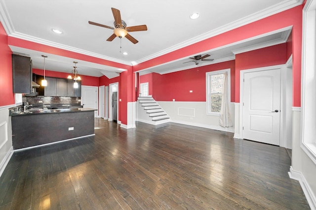 unfurnished living room featuring dark wood-style flooring, crown molding, recessed lighting, a ceiling fan, and wainscoting