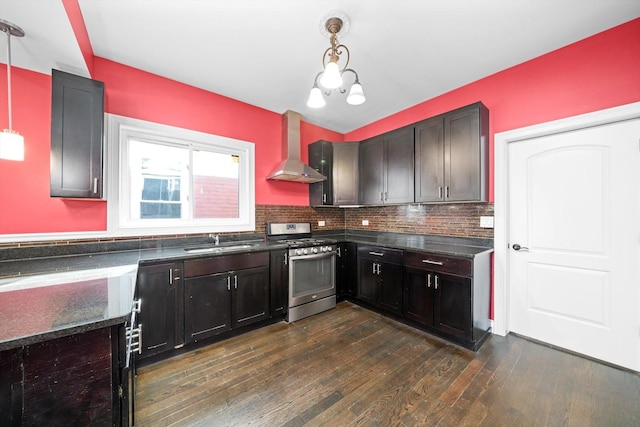 kitchen with extractor fan, dark wood-type flooring, a sink, hanging light fixtures, and stainless steel gas stove