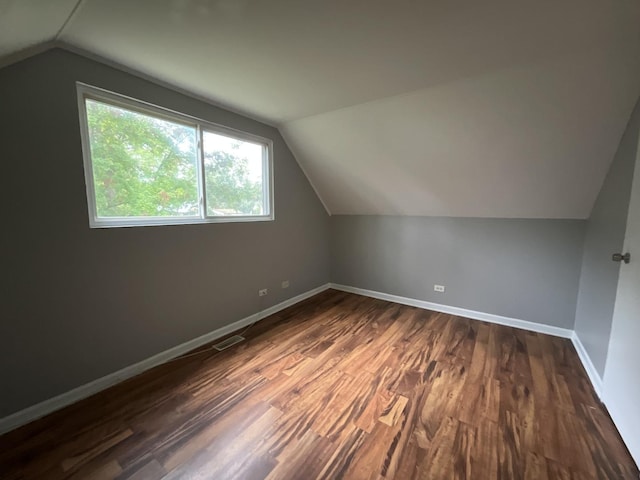 additional living space with dark hardwood / wood-style floors and lofted ceiling