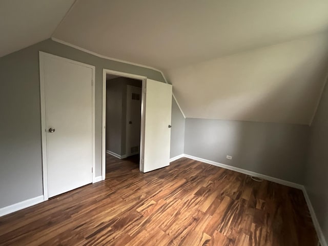 bonus room featuring dark wood-type flooring and vaulted ceiling