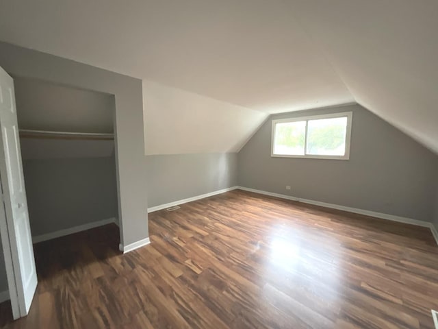 bonus room with dark hardwood / wood-style floors and lofted ceiling