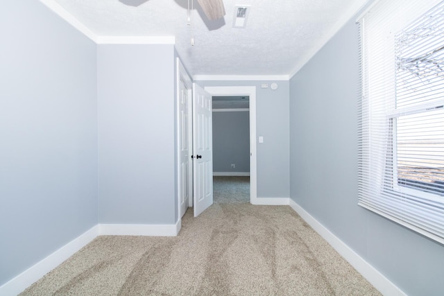 interior space with a textured ceiling, ceiling fan, and ornamental molding