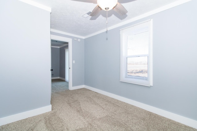 empty room featuring carpet, ceiling fan, ornamental molding, and a textured ceiling