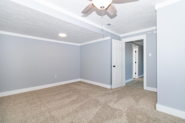 spare room with carpet floors, a textured ceiling, crown molding, and ceiling fan