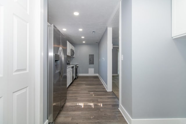 kitchen featuring dark hardwood / wood-style floors, electric panel, stainless steel appliances, and white cabinetry