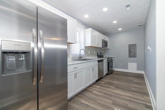 kitchen featuring dark wood-type flooring, white cabinetry, stainless steel appliances, sink, and electric panel