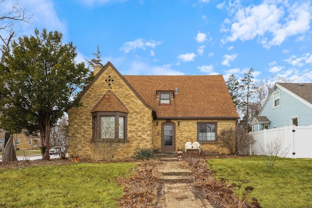 english style home with a front lawn