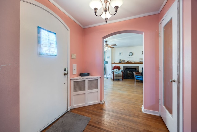 foyer entrance with crown molding, hardwood / wood-style floors, and ceiling fan with notable chandelier