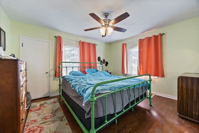 bedroom featuring multiple windows, hardwood / wood-style flooring, and ceiling fan