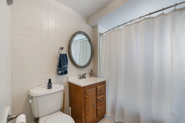 bathroom featuring tile walls, toilet, vanity, and crown molding