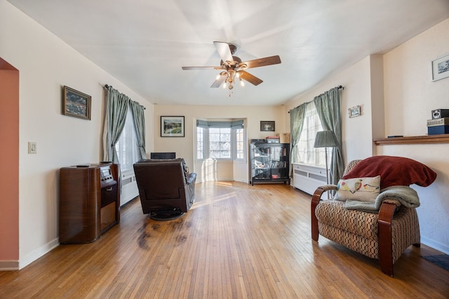 living area featuring ceiling fan, light hardwood / wood-style flooring, and radiator