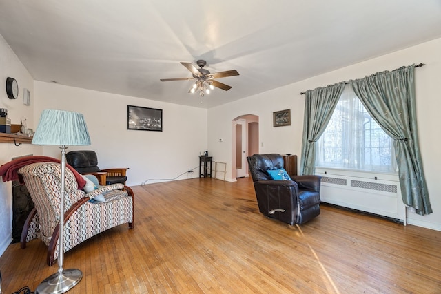 sitting room featuring hardwood / wood-style flooring, radiator heating unit, and ceiling fan