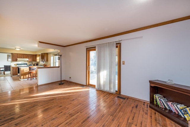 unfurnished living room with light hardwood / wood-style floors and ornamental molding