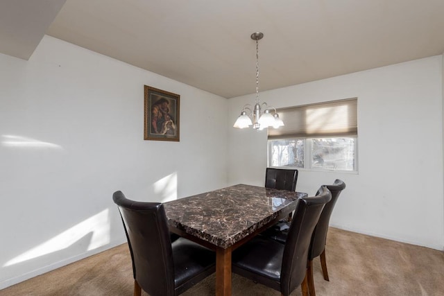 dining space with carpet and an inviting chandelier