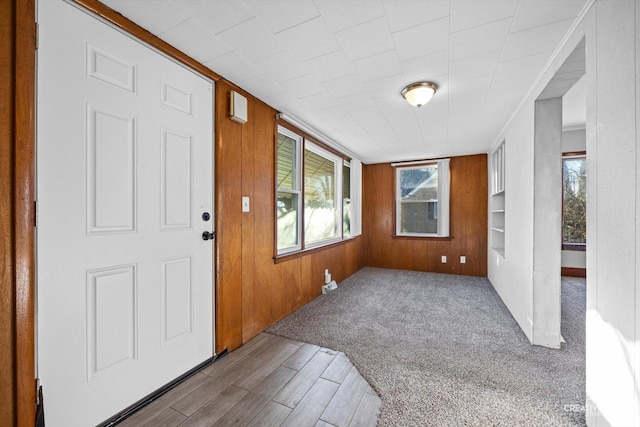 entrance foyer with wood-type flooring and wood walls