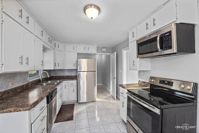 kitchen with white cabinetry, sink, light tile patterned flooring, and appliances with stainless steel finishes