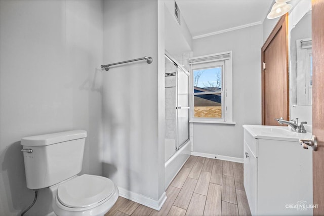 full bathroom featuring bath / shower combo with glass door, ornamental molding, vanity, and toilet