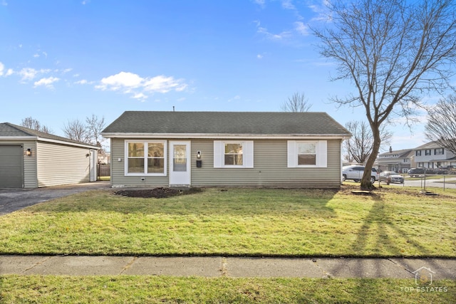 view of front of house featuring an outbuilding, a front lawn, and a garage