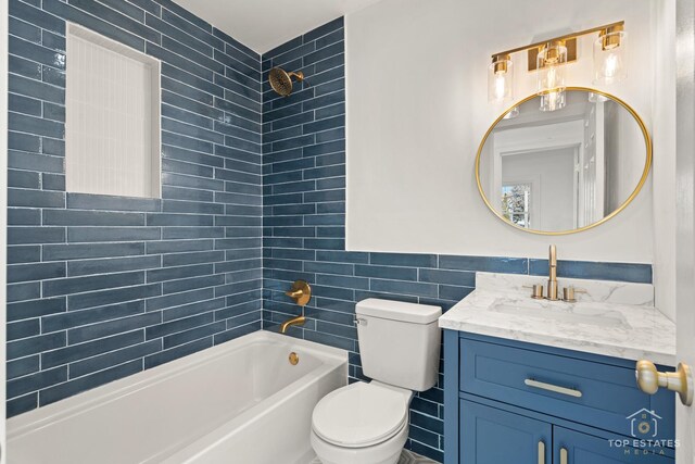 full bathroom featuring tiled shower / bath combo, toilet, tile walls, and vanity