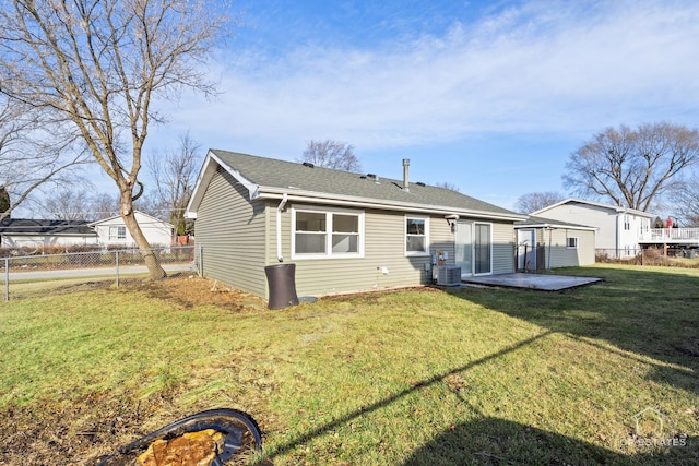 rear view of property featuring a yard, a patio, and central air condition unit