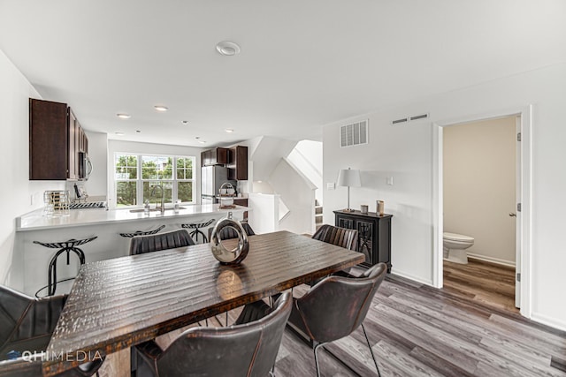 dining space featuring light wood-type flooring and sink