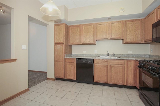 kitchen with sink, light tile patterned floors, black appliances, and decorative light fixtures