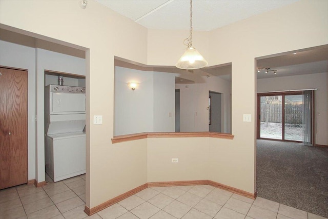 empty room with light carpet and stacked washer and dryer