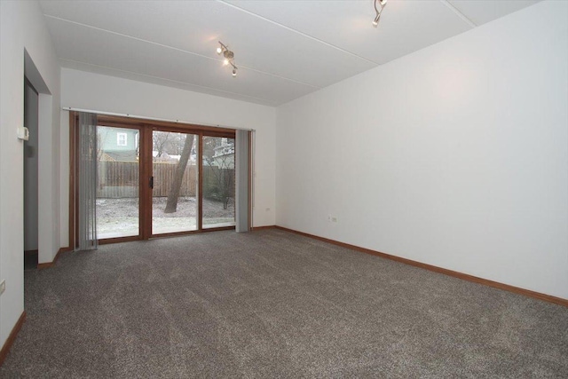 spare room with dark carpet