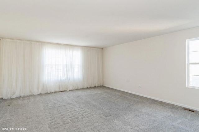 spare room with plenty of natural light and carpet