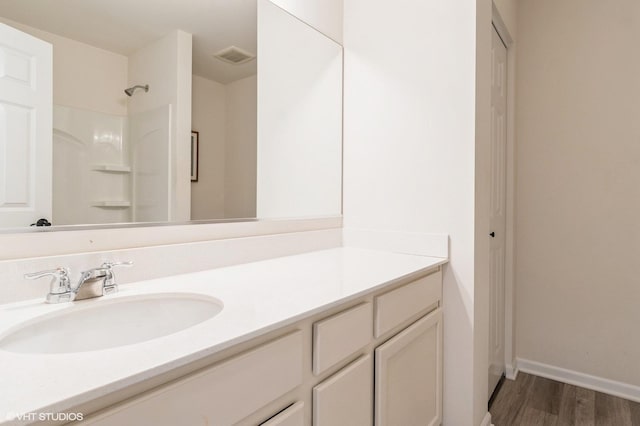 bathroom featuring vanity, hardwood / wood-style flooring, and a shower