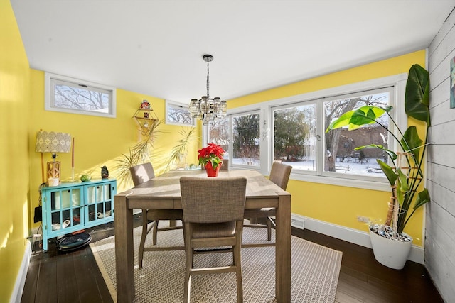 dining area featuring plenty of natural light, dark hardwood / wood-style floors, and an inviting chandelier