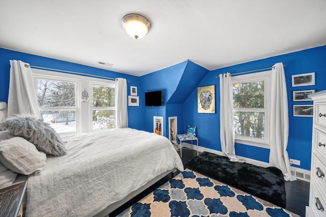 bedroom with lofted ceiling, dark hardwood / wood-style flooring, and multiple windows