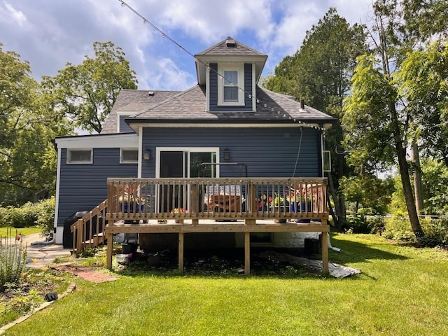 back of property featuring a deck and a lawn