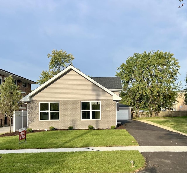 view of front of house with a garage, an outdoor structure, and a front yard