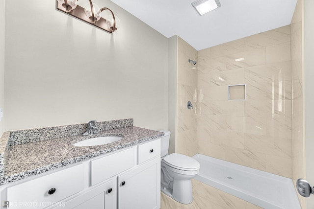 bathroom featuring vanity, toilet, and tiled shower