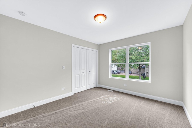 unfurnished bedroom featuring carpet floors and a closet