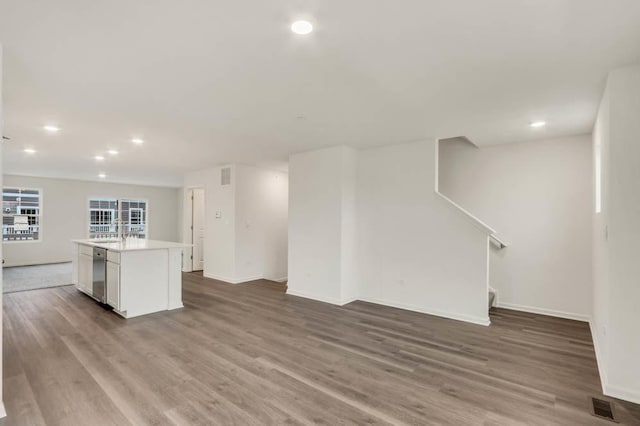 unfurnished living room with hardwood / wood-style flooring and sink