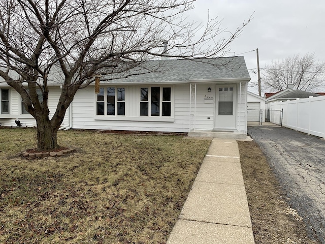 view of front of home with a garage, an outdoor structure, and a front lawn