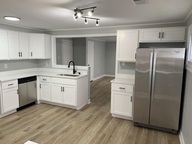 kitchen with sink, light hardwood / wood-style flooring, ornamental molding, appliances with stainless steel finishes, and white cabinetry